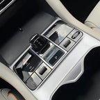 Black electronic gear shifter and silver metallic center console control panel in a car interior.