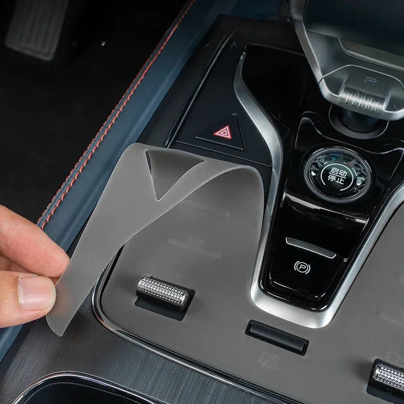 Translucent frosted protective film applied to a black car center console for scratch resistance.