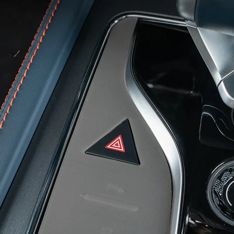 Close-up of a grey matte finish center console trim with a red hazard button for BYD cars.