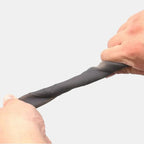 Hands stretching a durable, flexible grey silicone material to demonstrate elasticity.