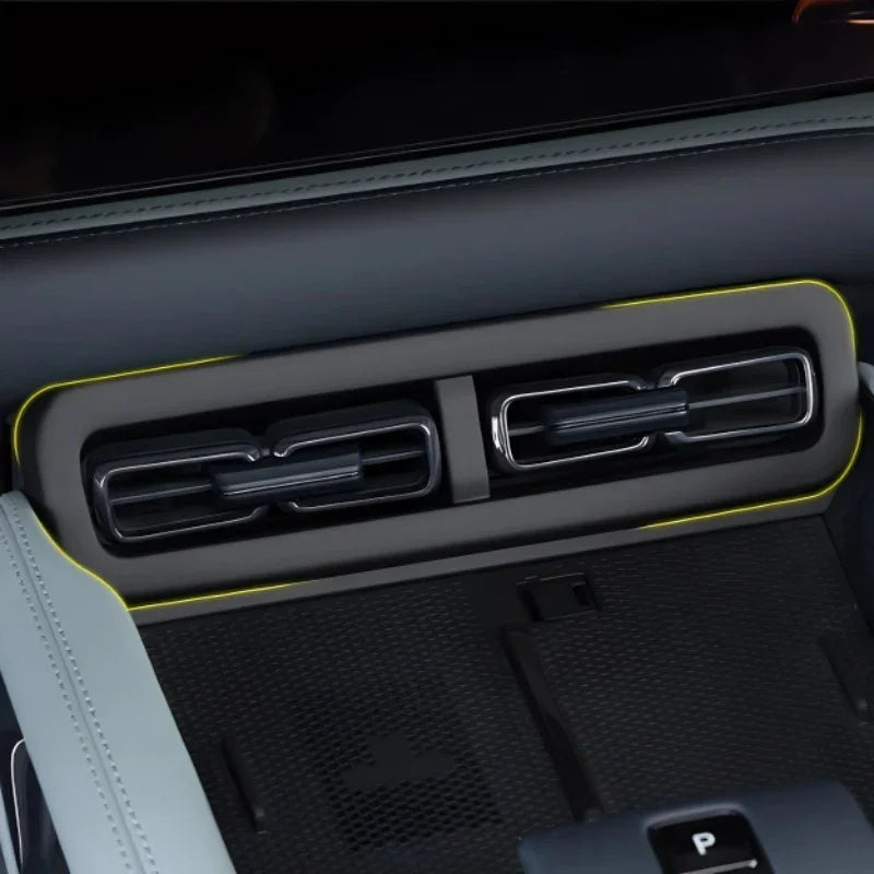 Sleek black car dashboard air vents with elegant yellow accent trim.