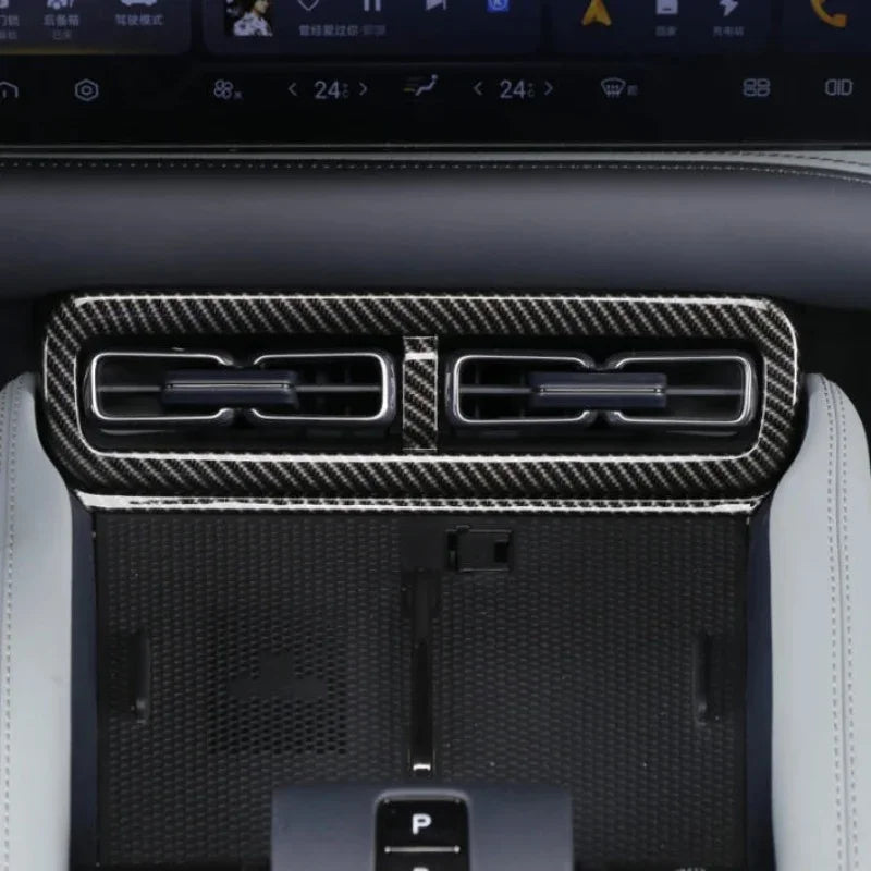 Black carbon fiber texture trim covering the dual car air conditioning vents.