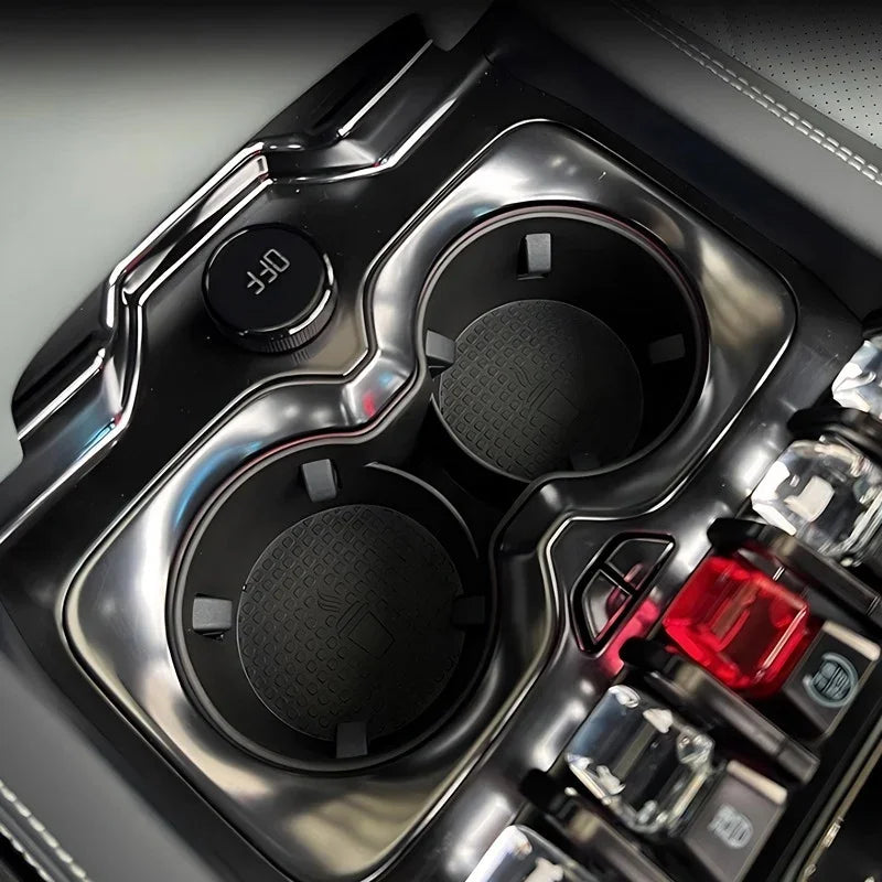 Glossy black BYD center console cup holder inserts with textured anti-slip pads.