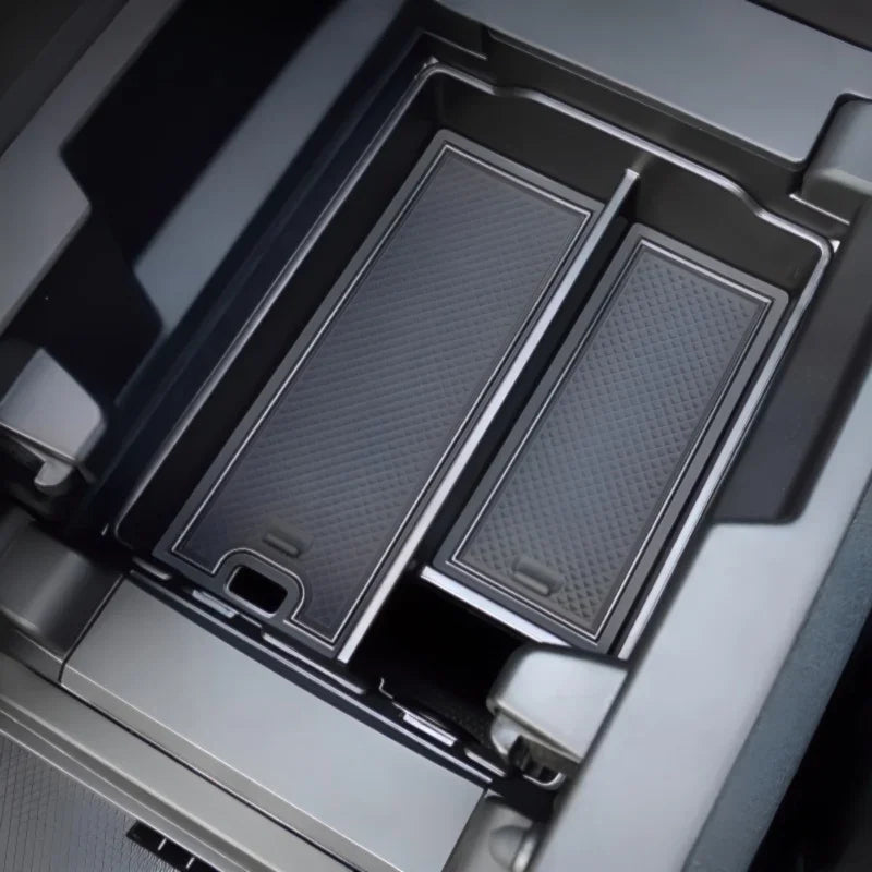 Black textured carbon fiber style organizer tray for BYD center console storage.