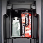 A white fragrance cream tube and red Nescafe instant coffee sachets stored in a black car organizer.