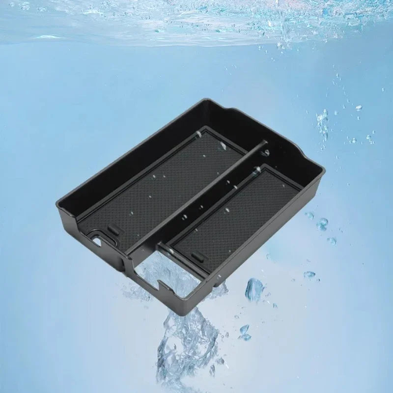 Waterproof black matte plastic center console organizer tray floating in blue water