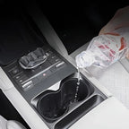 Water being spilled into a durable black matte car center console cup holder.