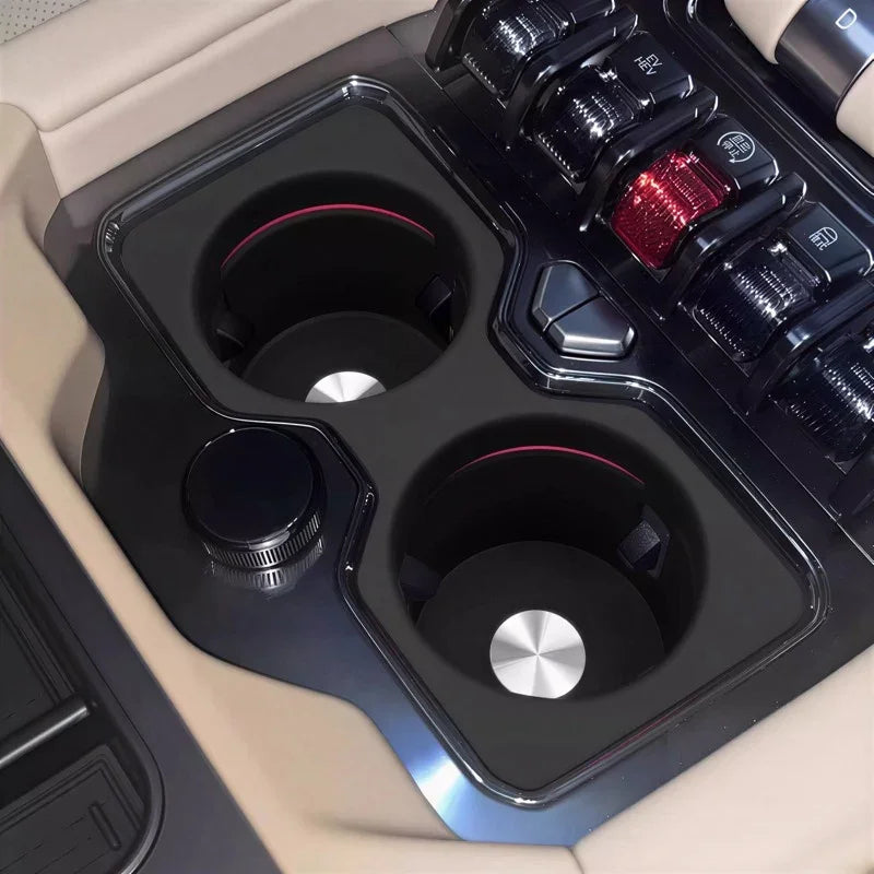 Dual black matte cup holders with silver metallic accents in a beige car interior.
