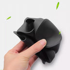 Hand squeezing a flexible, matte black silicone collapsible cup.