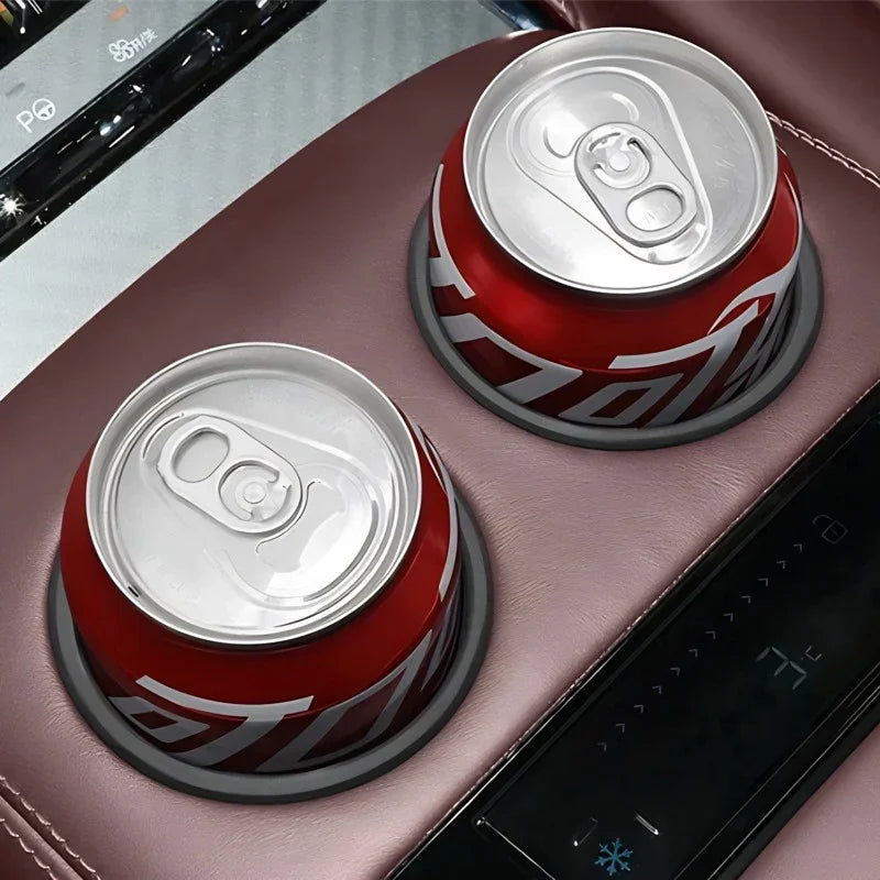 Two red aluminum beverage cans secured in premium brown leather car center console cup holders.