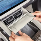 Light grey ABS plastic dashboard storage tray installed above the car air vents.