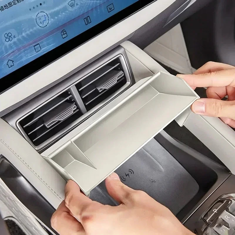 Light grey ABS plastic dashboard storage tray installed above the car air vents.