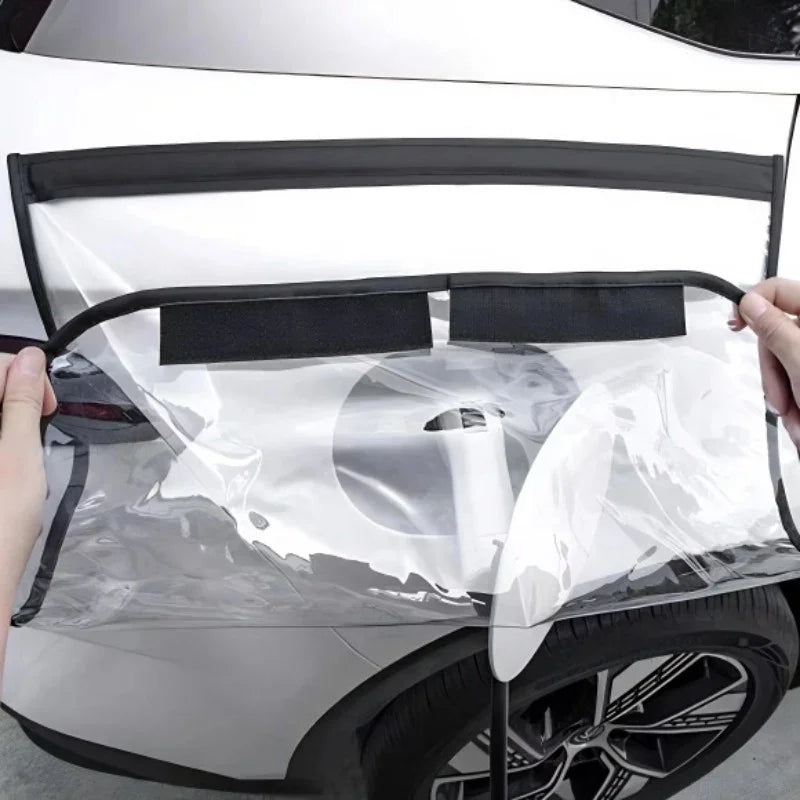 Clear protective film with black trim being applied to a white car's rear bumper.