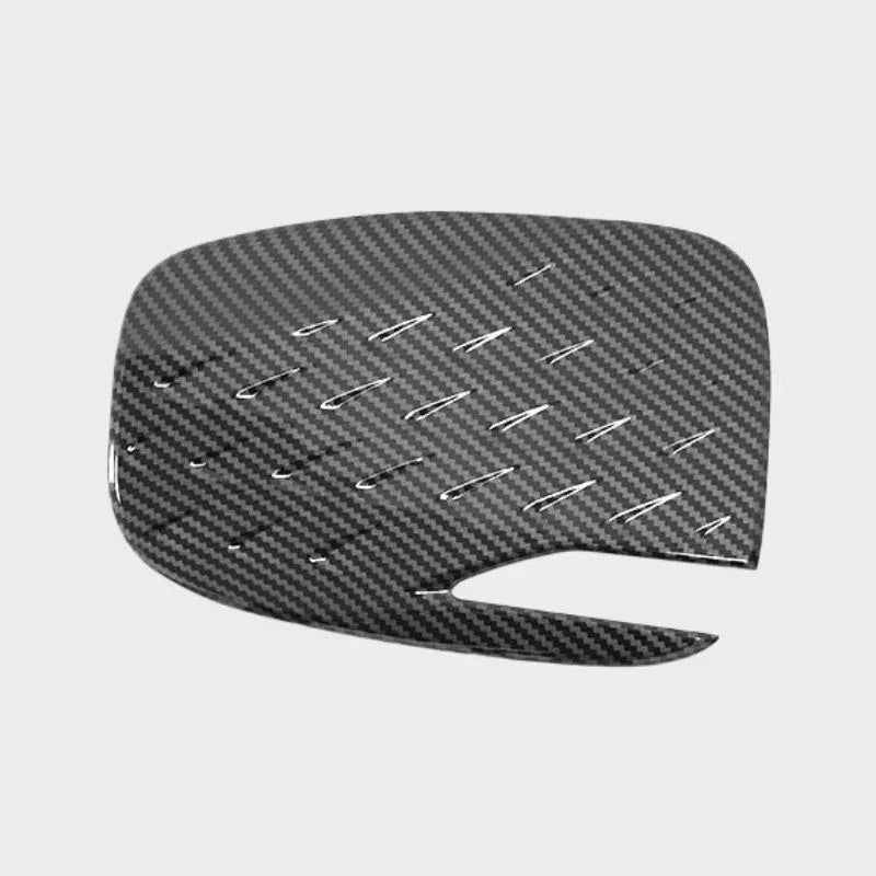 Black carbon fiber texture interior trim accessory with a sleek, glossy finish.