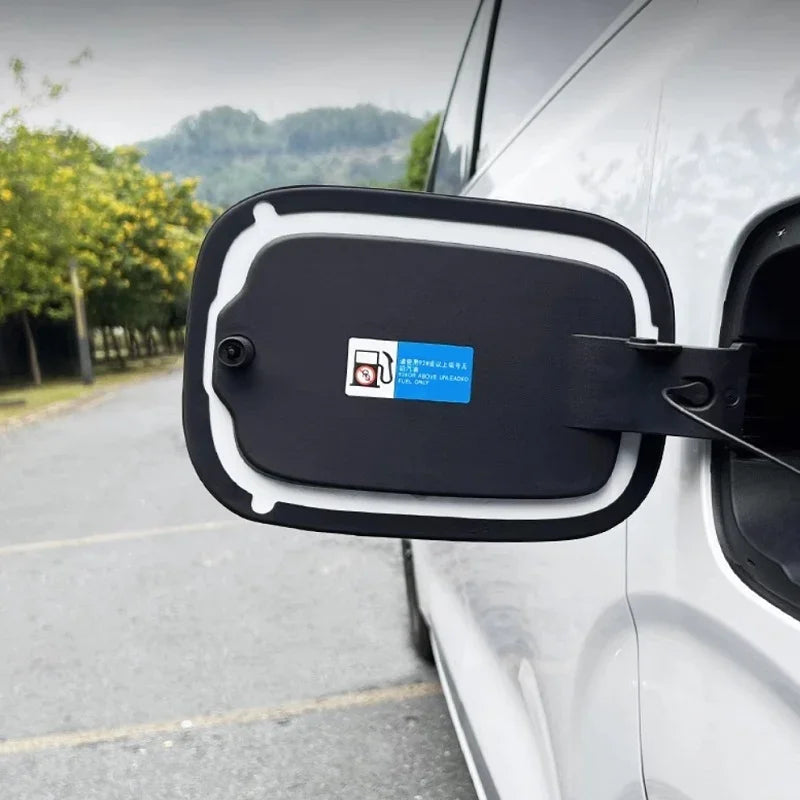 Black matte fuel door cover with protective white trim and charging port indicator sticker.