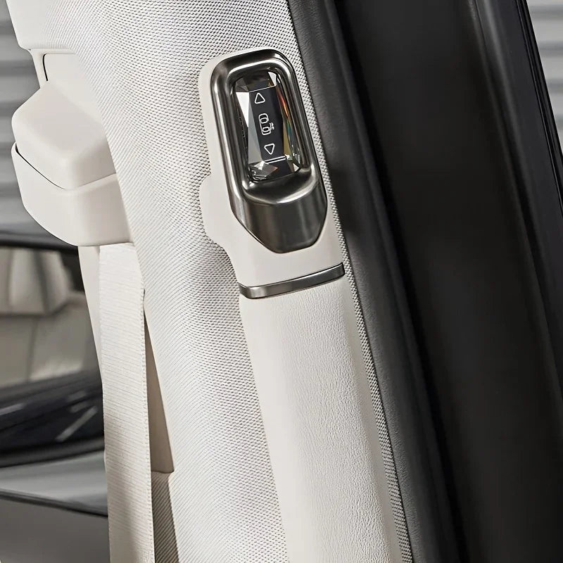 Close-up of a silver window control switch mounted on a white textured car door panel.