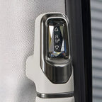 Close-up of a sleek white and metallic silver window control switch on a car door panel.