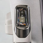 Close-up of a sleek, metallic silver window control switch with a polished finish on a textured light gray interior panel.