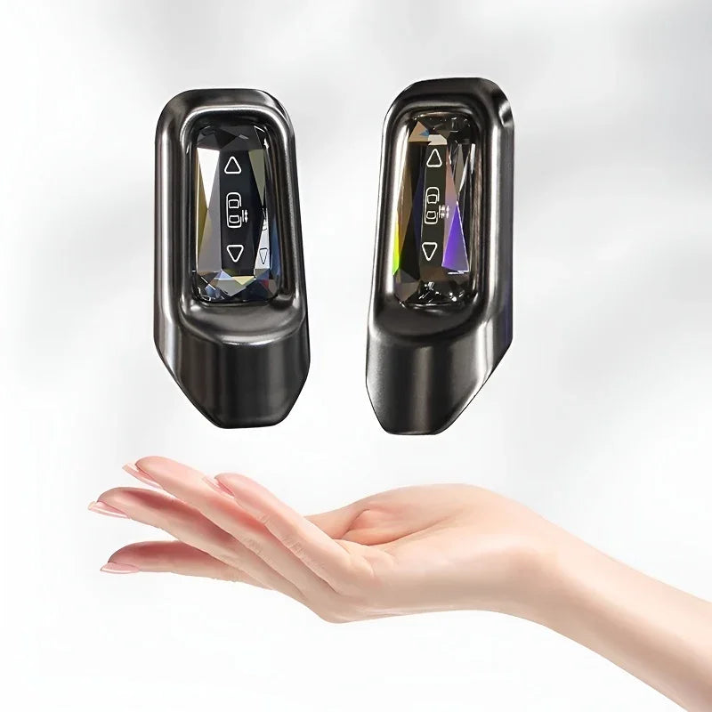 Two sleek black BYD car remote keys with sparkling diamond-style crystal buttons floating above a hand.
