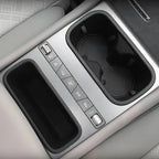 Silver metallic center console featuring dual black cup holders and integrated storage compartment.