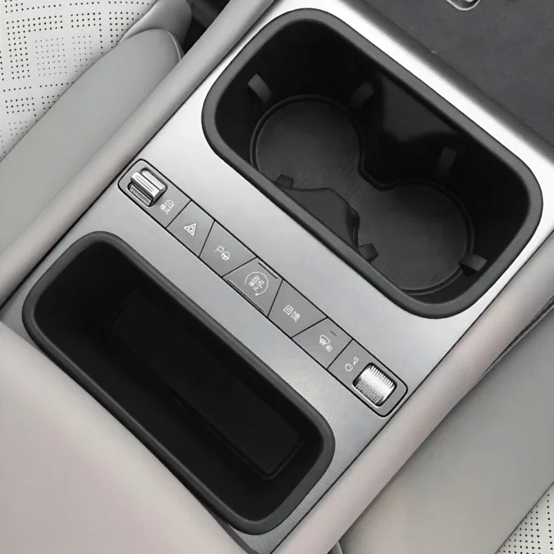 Silver center console with black dual cup holders and integrated storage tray for BYD models.