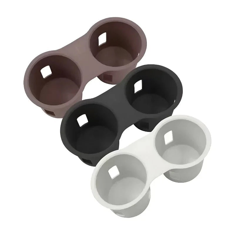 Three dual car cup holder inserts in silicone material, available in mauve, black, and white.
