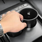 Black matte car cup holder expander accessory installed in vehicle center console.