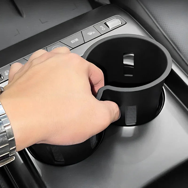 Black matte car cup holder expander accessory installed in vehicle center console.