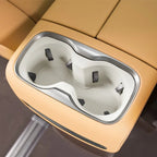 Tan leather car center console with dual white plastic cup holders and silver trim.