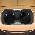 Dual black matte cup holders with silver trim integrated into tan leather car interior.