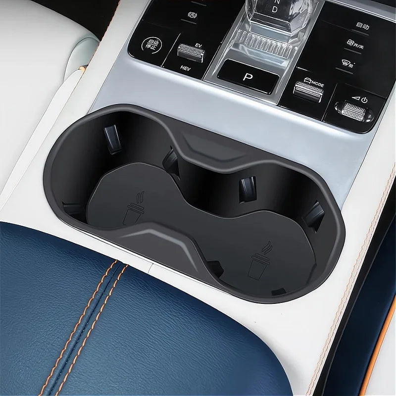 Black matte dual cup holder integrated into a white and blue leather car interior console.