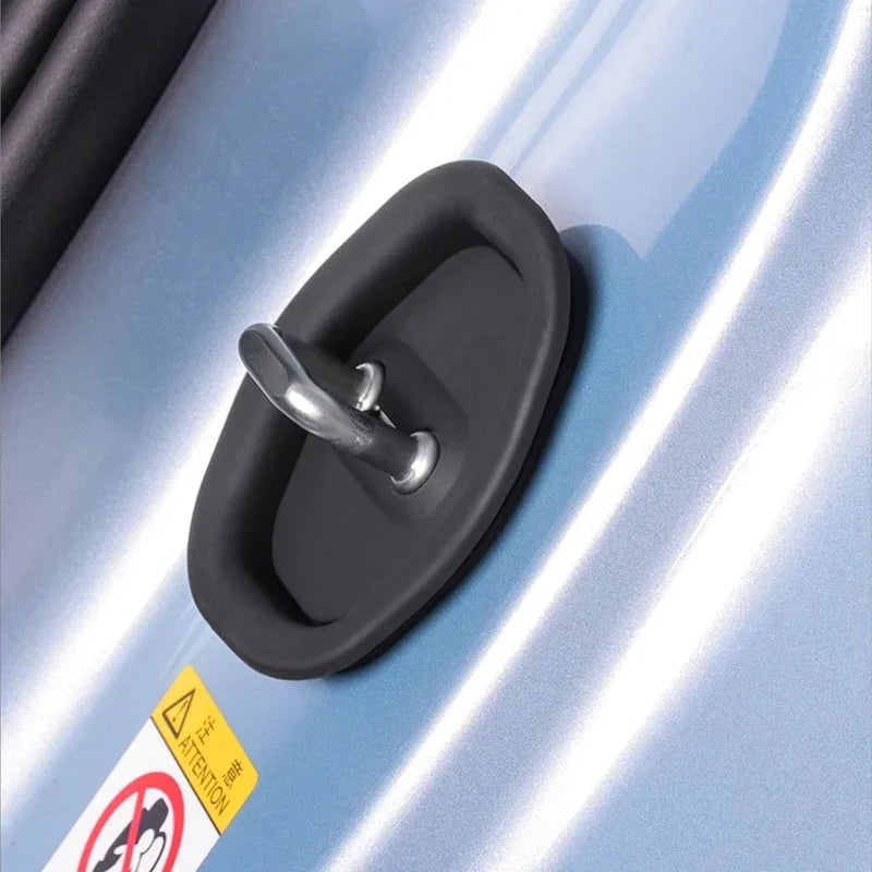 Black rubber-coated metal door handle lock mechanism on a light blue car surface.