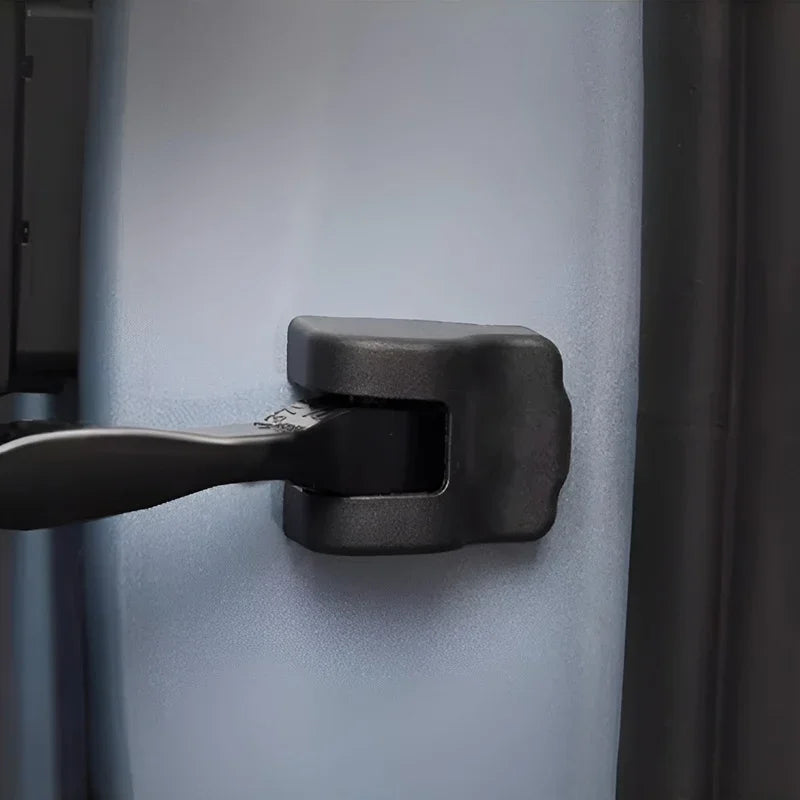 Black durable plastic latch mechanism installed on a light grey protective car interior panel.
