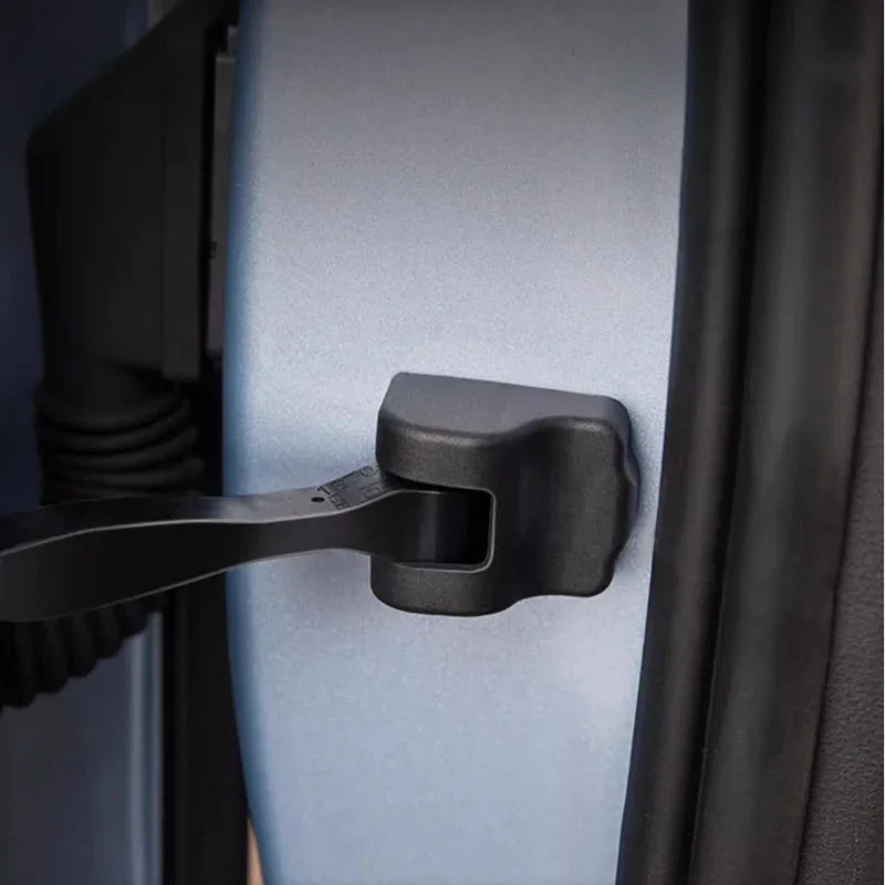 Black durable plastic door latch protector installed on a silver car door edge.