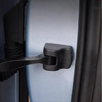 Black durable plastic door latch protector installed on a silver car door edge.