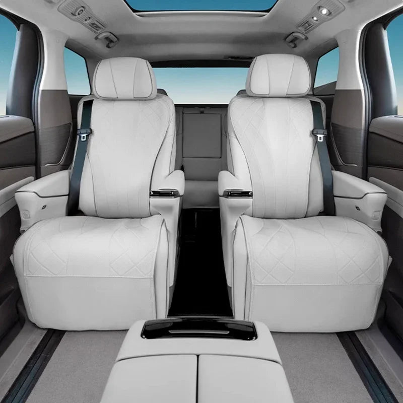 Luxury white leather rear car seats with diamond stitching and matching armrests.