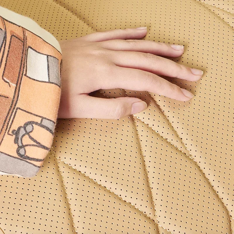 Close-up of a hand touching tan perforated faux leather car seat cover with diamond stitching.