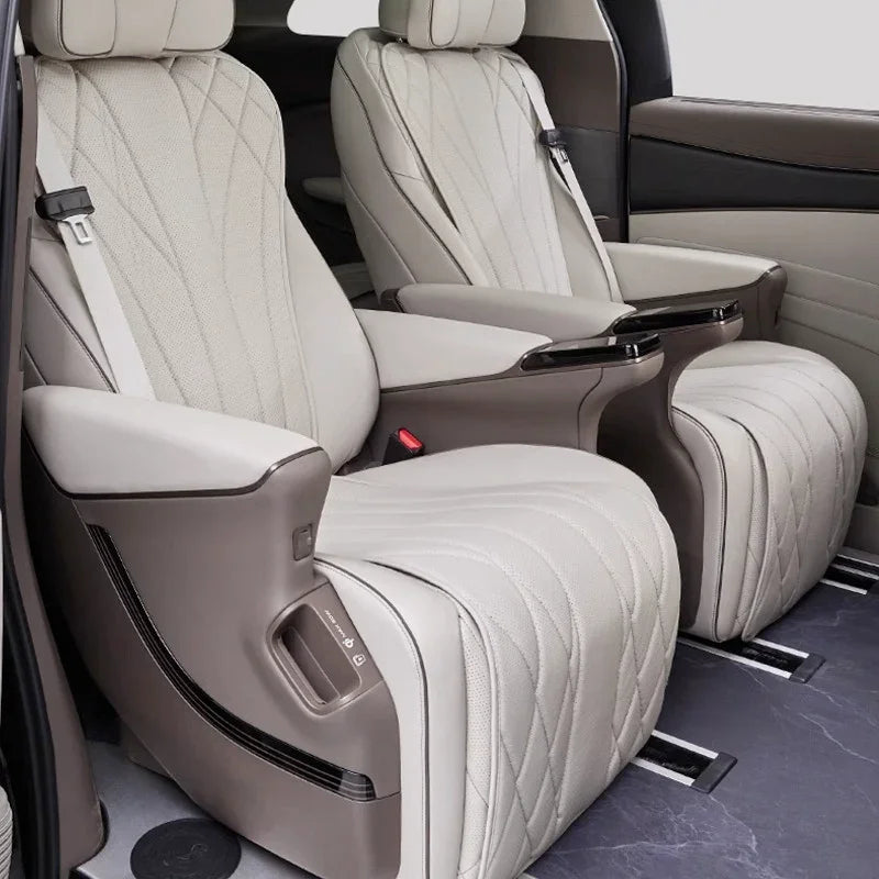 Luxurious beige leather car seats with diamond-quilted stitching and adjustable armrests.
