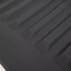 Close-up of a black textured waterproof car mat featuring durable anti-slip ridges.