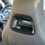 Close-up of a black carbon fiber trim insert for a car seat headrest