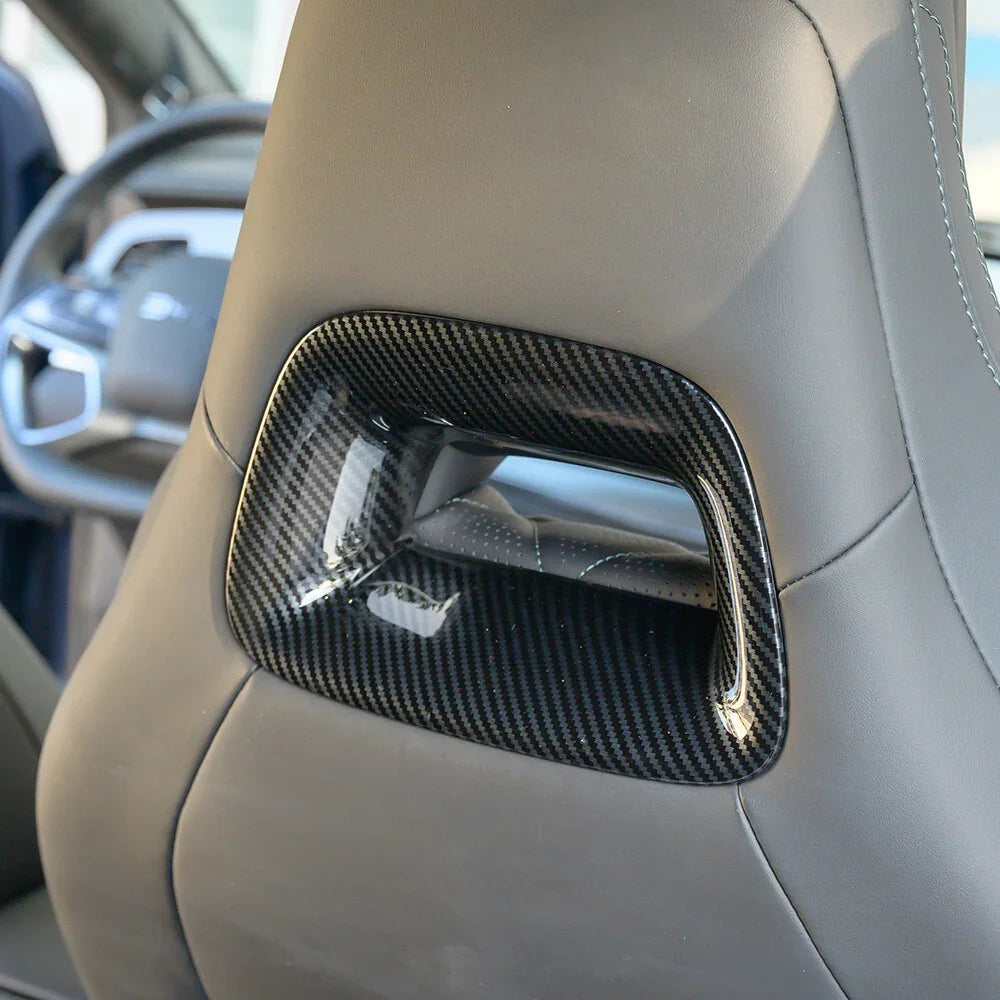 Close-up of a black carbon fiber trim insert for a car seat headrest