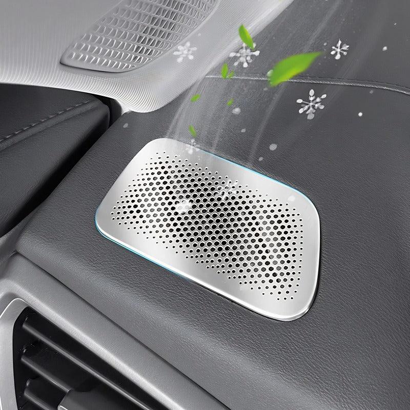 Silver perforated metal car air purifier emitting cool air with green leaves and snowflakes