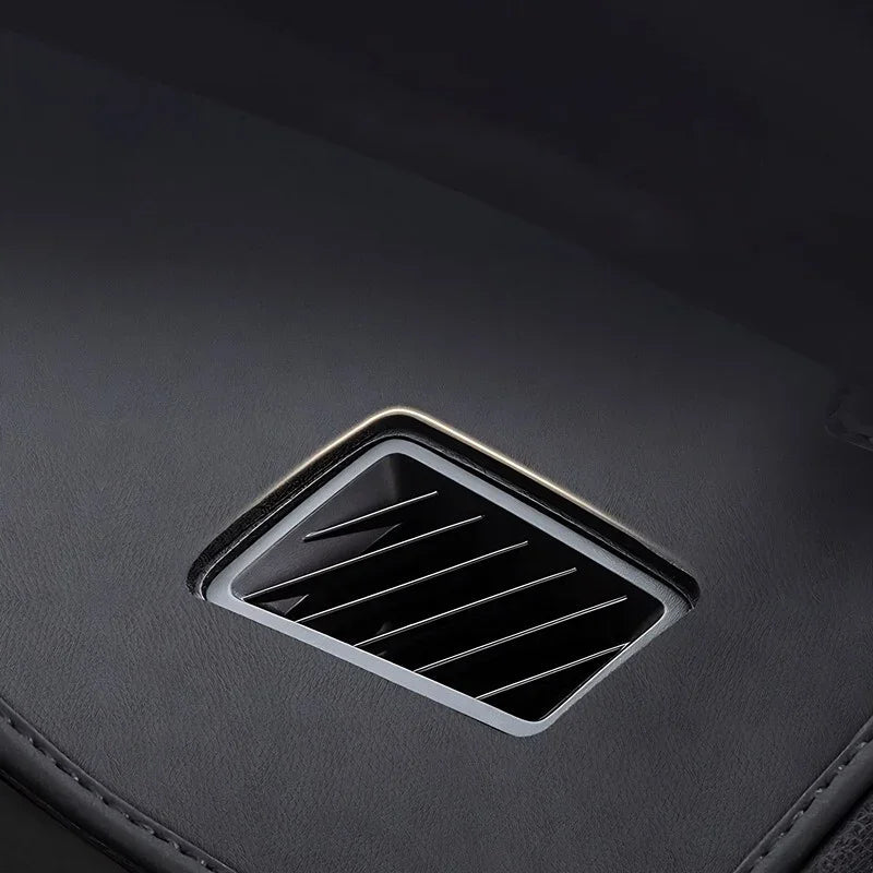Black leather interior with a sleek silver-rimmed rectangular air vent.