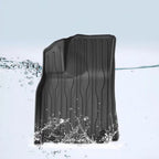 Black waterproof heavy-duty rubber car floor mat being splashed with water
