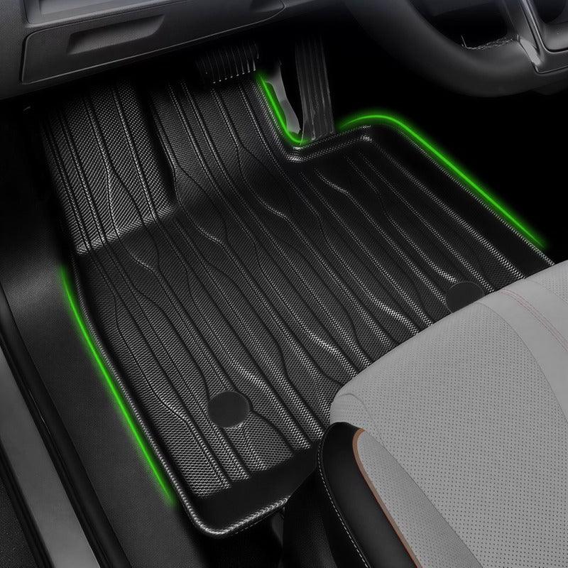 Black heavy-duty rubber car floor mat with textured pattern and green LED accent lighting.