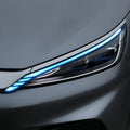 Close-up of a sleek grey car featuring modern blue LED headlight accents.