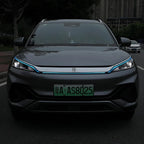 Front view of a grey BYD electric car featuring a distinctive blue LED light strip across the grille.