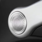 Close-up of a silver metallic speaker grille on a sleek automotive interior component.