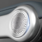 Close-up of a silver metallic speaker grille with a perforated pattern on a grey automotive accessory.