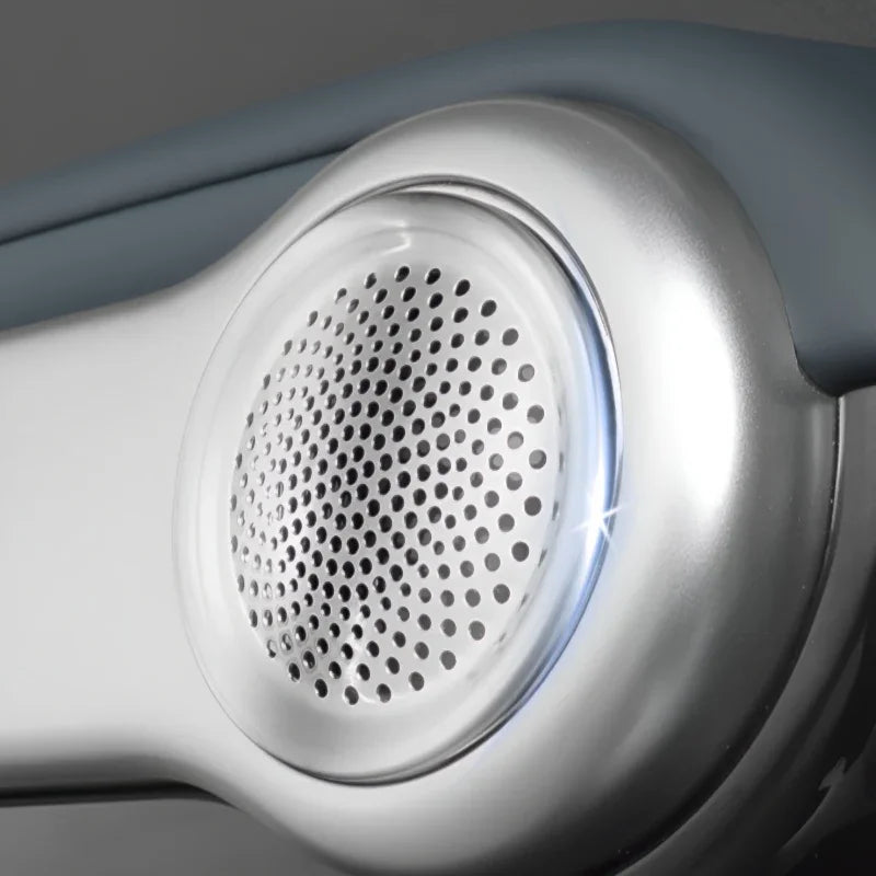 Close-up of a silver metallic speaker grille with a perforated pattern on a grey automotive accessory.